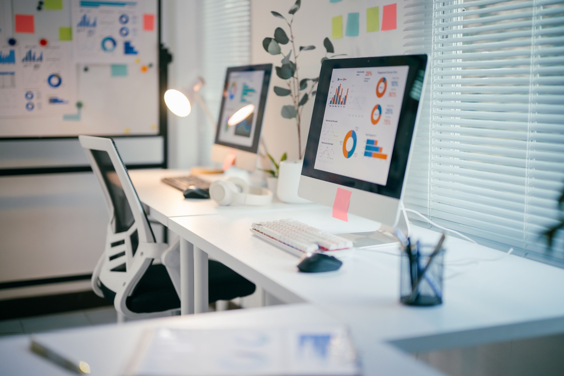 Modern office workstation illuminating marketing data analysis on computer screens, showcasing professional workspace with analytical charts and graphs